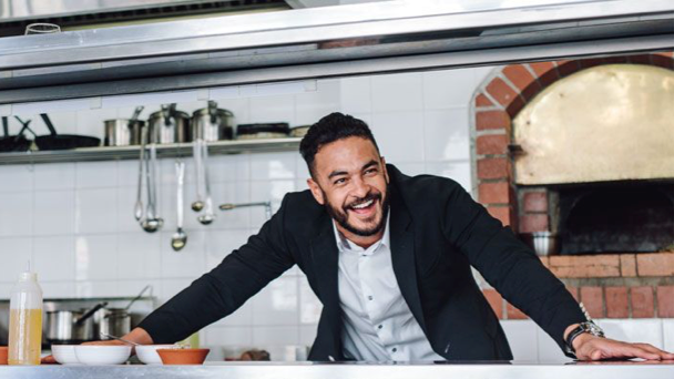 Man smiling behind counter