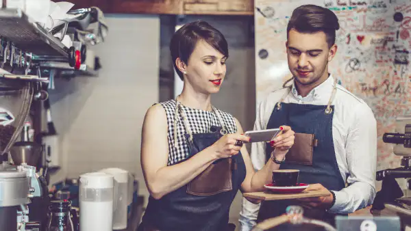 Coworker taking picture of coffee to post on social media